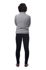 rear view of a woman with sportswear and arms crossed on white background