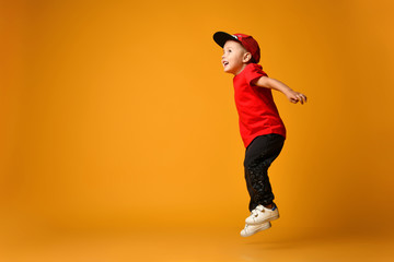 Fototapeta na wymiar Little boy jumping on isolated yellow background
