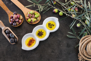Mixed types of olive in the bowls and olive oil on the table