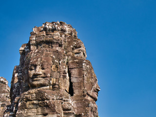 Giant stone faces in temple ruins at the ancient Khmer site of Angkor Thom near Siem Reap in Cambodia.