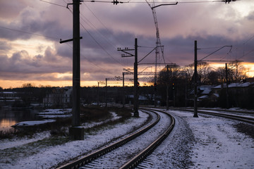Fototapeta na wymiar Railroad tracks in a winter foggy morning sprinkled with snow.