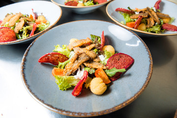 Salad with fried fish fillet red mullet.