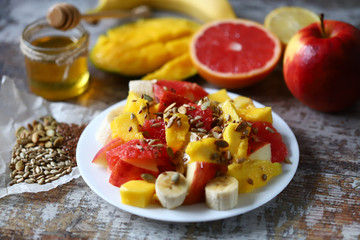 Fruit salad with honey and seeds. Healthy breakfast or snack. Vegan Dessert. Selective focus. Macro.
