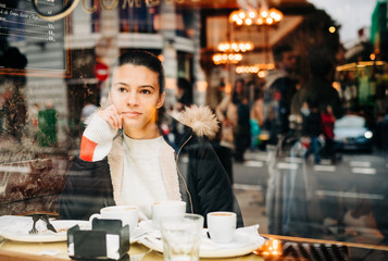Woman looking out window in coffee shop