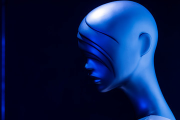 Short-haired plastic female mannequin head on black background