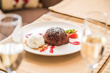 Chocolate fondant on a squirrel plate with strawberries and ice cream.