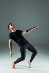 Obraz premium handsome dancer in black leggings and t-shirt dancing contemporary on dark background