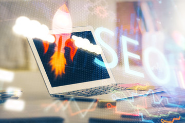 Multi exposure of table with computer and seo drawing hologram. Search optimization concept.