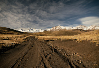 Pov. Dirt Road across the yellow meadow into volcano Domuyo in the Andes mountains, Patagonia Argentina