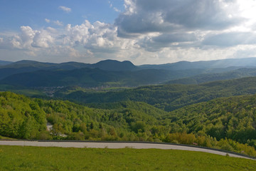 Obraz premium Landscape with curvy road at summer sunset.
