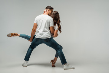 back view of dancers dancing bachata on grey background with copy space