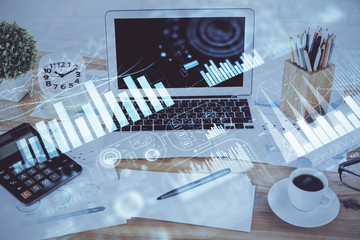 Stock market graph on background with desk and personal computer. Double exposure. Concept of financial analysis.