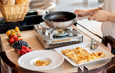 Chef's hands  stirring mixed berries jam for compote and bread pudding