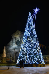 Florence, December 2019: Illuminated Christmas tree in Piazza Santa Maria Novella with the Basilica on the background. Italy.