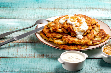 Exposition of home made potato pancakes on wooden table, traditional tasty food.

