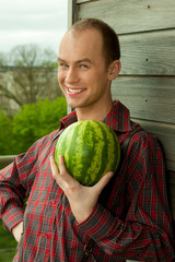Fototapeta premium Young farmer holding a fresh watermelon