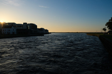 Galway city at sunrise - taken from the Claddagh, showing the harbor and buildings on a clear morning by the River Corrib