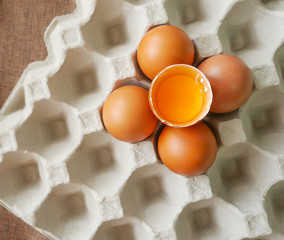 Concept healthy food, Fresh chicken eggs and yolk in eggshell on paper tray-top view