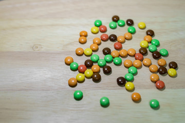 Many colorful candies on a wooden background