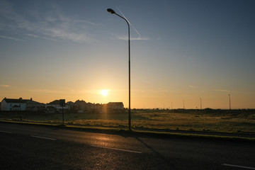 Sunlit road along the Wild Atlantic Way, going along Salthill promenade near Galway, in ireland. Tekan at sunrise on a sunny day.
