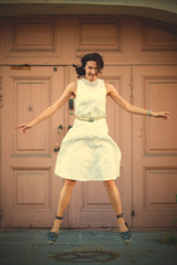 smiling woman in a white dress hovers above the ground