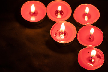 Red candles on a black background. Fire in the dark. Candle light. Light it up. Forever.