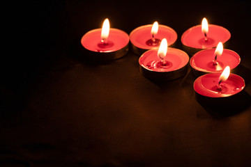 Red candles on a black background. Fire in the dark. Candle light. Light it up. Forever.