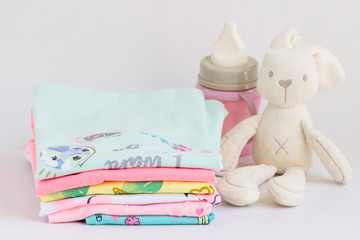 Summer clothes for small children with a toy  rabbit and a bottle milk .