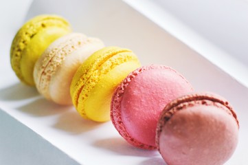 Vanilla, banana, strawberry and chocolate dessert on a table. Almond cookies of different colors. Delicious macaroons close up photo