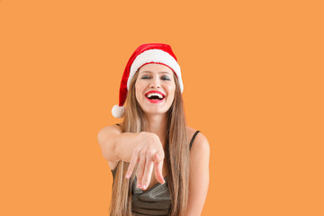 Beautiful young woman in Santa hat on color background