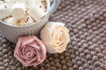 Obraz na płótnie Canvas Marshmallow looks like rose close-up. cup with small marshmallows sprinkled with grated chocolate on cotton knitted napkin.