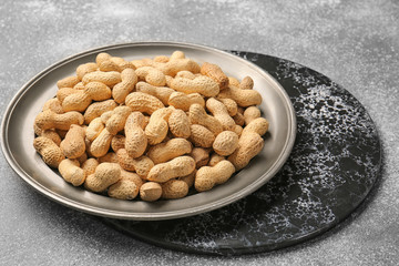 Tray with peanuts on grey background