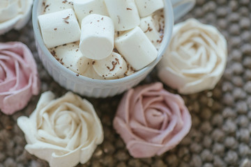Homemade marshmallows around grey cup with cocoa or hot chocolate over the top.