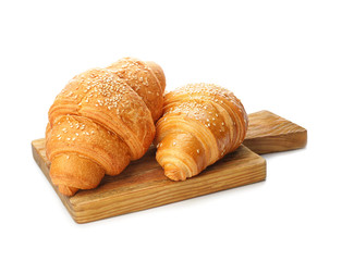 Board with tasty croissants on white background