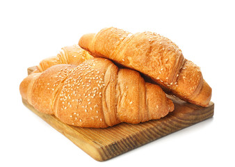 Board with tasty croissants on white background