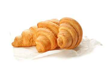 Parchment with tasty croissants on white background