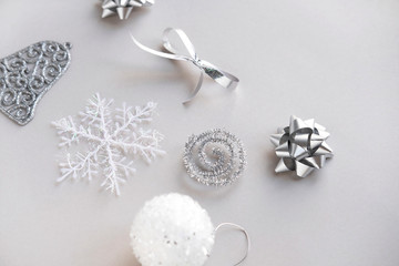 New Year decoration on gray background. Winter holidays concept. New Year and Christmas snowflake, ball, ribbon bell
