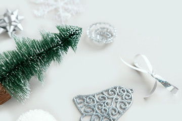 New Year decoration on gray background. Winter holidays concept. New Year and Christmas snowflake, ball, ribbon bell, green tree