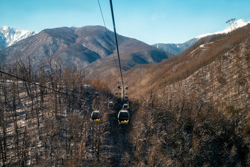 The suspension road to the mountains in winter is the beginning of the ski resort.