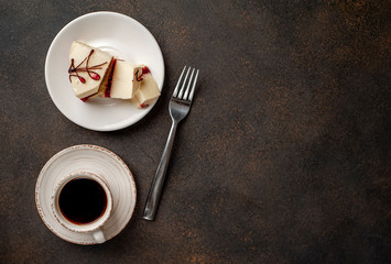 Coffee and tasty cheesecake on a plate on a stone background with copy space for your text, breakfast concept