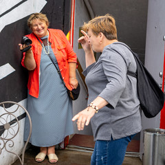 Two Mature plump women walk around the old town and are photographed