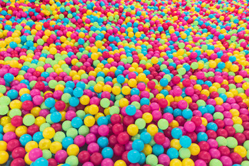 Fototapeta na wymiar texture on the wallpaper a lot of colorful balls in a heap, a children's pool for games of preschool age, bright colors, spherical shape, cause emotion joy, background, material plastic.