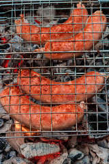 Sausages on the grill are grilled on the coals in the open air.