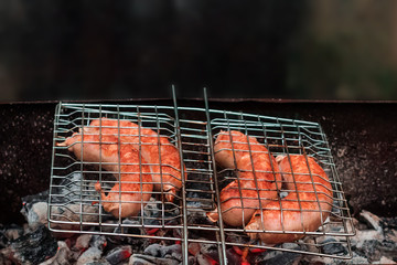 Sausages on the grill are grilled on the coals in the open air.