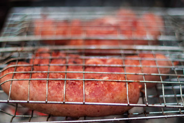 Sausages on the grill are grilled on the coals in the open air.