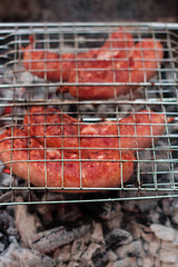 Sausages on the grill are grilled on the coals in the open air.
