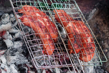 Sausages on the grill are grilled on the coals in the open air.