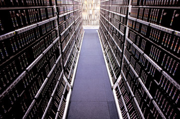 Narrow aisle amidst computer data storage drives in racks