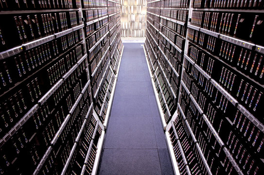 Narrow Aisle Amidst Computer Data Storage Drives In Racks