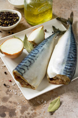 Fresh raw fish. Mackerel and ingredients for cooking on a stone countertop.